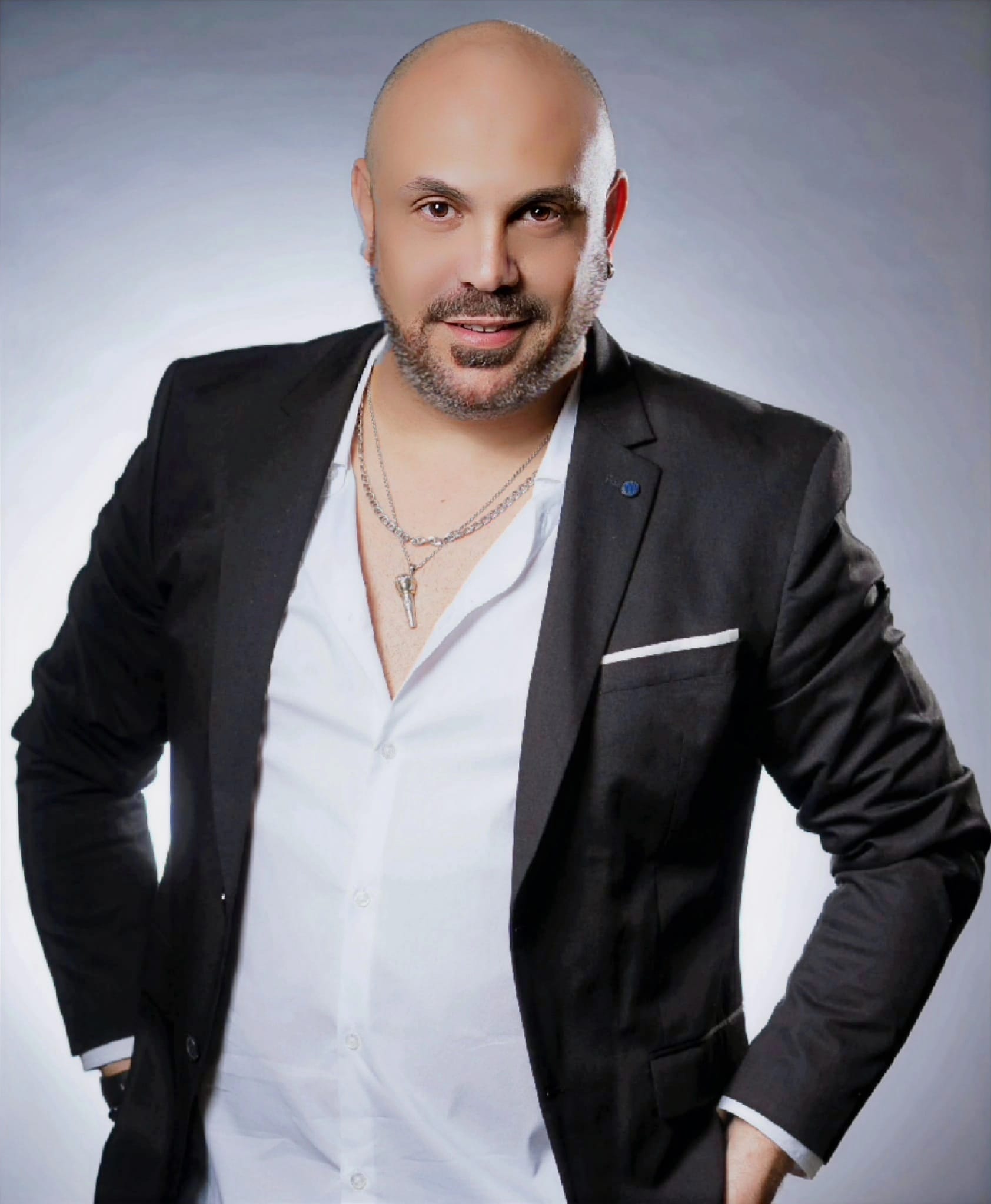 תמונה של אסי יחיאל בחליפה מחוייך