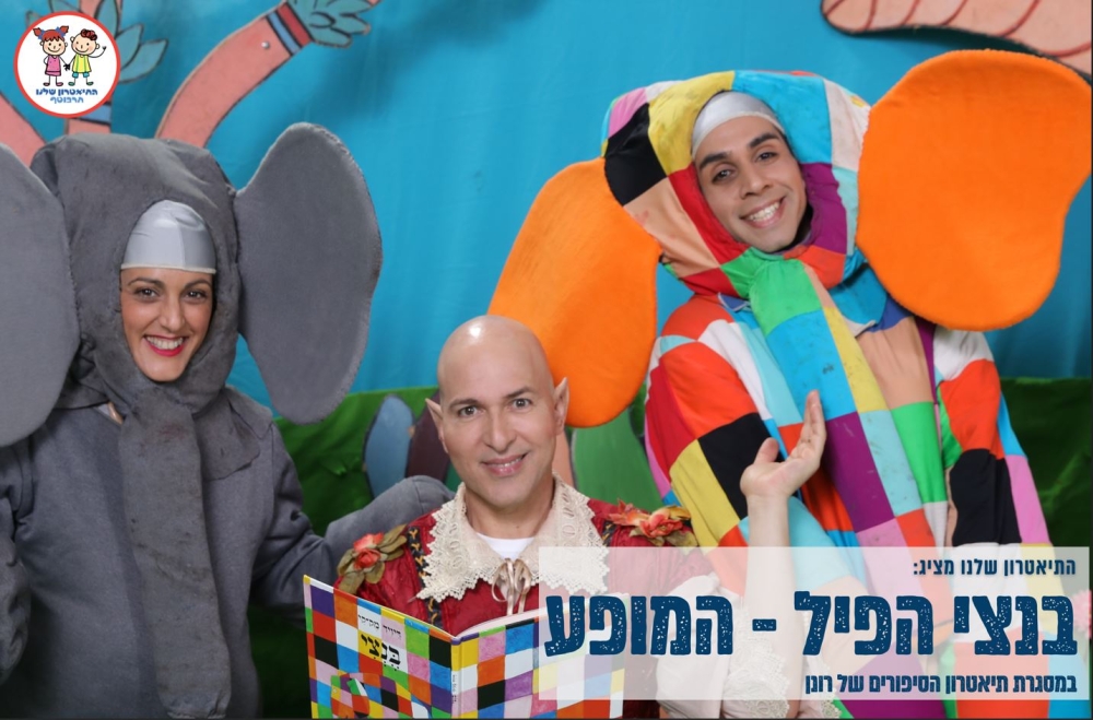 תמונה של שני שחקני ההצגה לבושים כפילים ובניהם מספר ההצגה